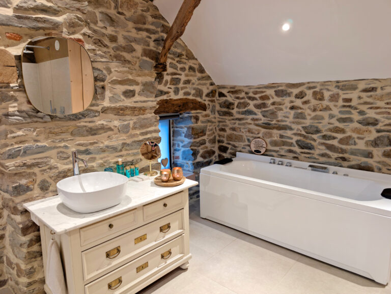 Baignoire et mur de pierre au Paddock Lodge à Stoumont